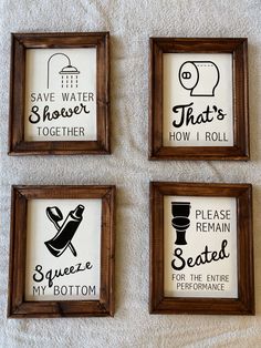 three framed pictures with different sayings in them on a white towel next to a toilet paper roll