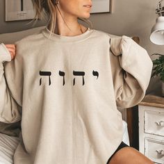 "✨Welcome to Faithful Deliveries!✨ 50% of all profits are donated to Kingdom-minded causes, so thank you for your support and business! ✨Product Details✨ Make a statement with this trendy Yahweh sweatshirt. This soft, comfy crewneck features the Hebrew letters י ה ו ה (pronounced Yahweh), notably known as the Name God gives Himself in Exodus 3. Used throughout the Bible, this Name means \"I am,\" as God is sufficiently self-sustaining, self-existing, and the Creator of all. ✨Material & Care✨ This product is the classic Gildan 18000 Unisex Heavy Blend™ Crewneck Sweatshirt. This soft, comfy sweatshirt features a ribbed-knit collar to retain shape after washing, a loose fit, a sewn-in label, and no itchy side seams. It is 50% cotton, 50% polyester, and has a medium-heavy fabric (8.0 oz/yd² (2 Yahweh Sweatshirt, Kingdom Minded, Faith Sweatshirt, Exodus 3, Comfy Crewneck, Jesus Sweatshirts, Hebrew Letters, Christian Sweatshirt, Names Of God