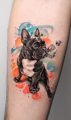 a tattoo with a dog on it's arm and watercolor paint splatters