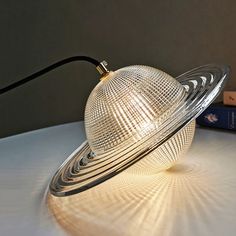 a light that is sitting on top of a table next to books and a book