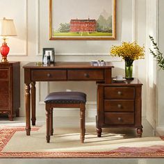 a desk and chair in a room with a painting on the wall