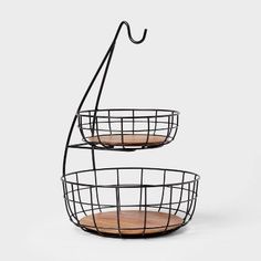 three tiered metal basket with wooden plates in it and an iron hook on the top