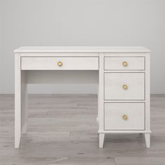 a white desk with two drawers and gold handles