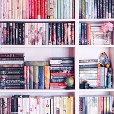 a white book shelf filled with lots of books