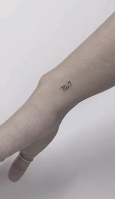 a person's arm with a small tattoo on the left side of their hand