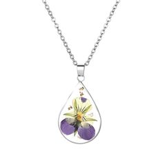 a purple flower in a tear shaped pendant