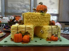 a cake made to look like hay with pumpkins on it