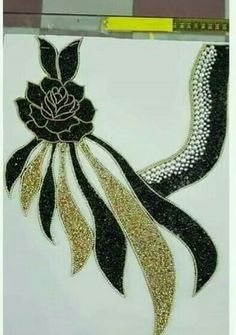 an image of a painting with gold glitters on white paper and a black ribbon