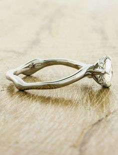 a diamond ring sitting on top of a wooden table