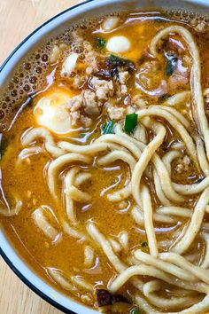 a bowl of soup with noodles and meat in it