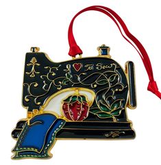 an ornament shaped like a sewing machine with a red ribbon hanging from it