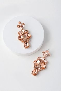 two pairs of earrings sitting on top of a white plate