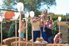 some people and children are playing in the hay