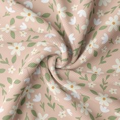 a pink and white flowered fabric with green leaves on it's side,