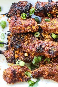 some food is on a white plate with green onions and seasoning sprinkles