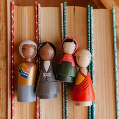 three wooden dolls sitting on top of a book