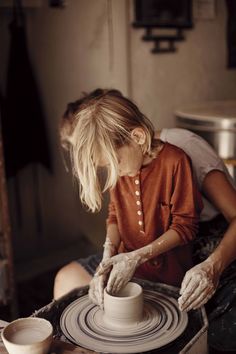 a woman is making a pot on a potter's wheel