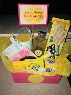 a pink box filled with lots of food and drinks next to a sign that says have an easy peasy lemonade summer