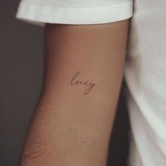 a woman's arm with the word love tattooed on it, in cursive writing