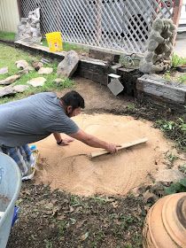 a man is digging in the dirt with a shovel and some other items around him