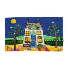 a door mat with a house on the front and trees in the back ground, at night