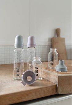 three baby bottles sitting on top of a wooden counter