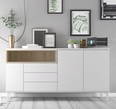 a white and wood sideboard in a room with pictures on the wall above it