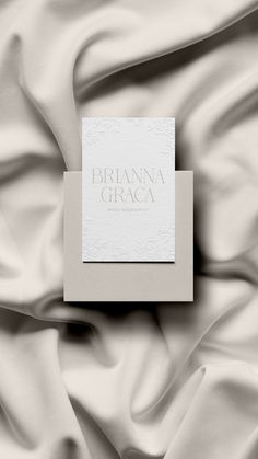 a white book sitting on top of a bed covered in satin material with the words, bridalna graca