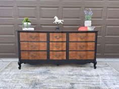 an old dresser is painted black and brown