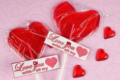 two lollipops in the shape of hearts with i love you written on them