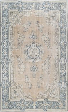 an antique rug with blue and white designs on the border, in neutral tones that appear to be hand - knotted