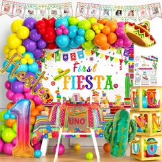 a birthday party with colorful balloons and decorations on the wall, including a sign that says first fiesta