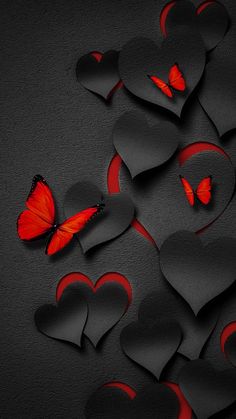 some red hearts and a butterfly on a black background