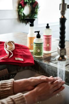 two bottles of hand sanitizers sitting on a counter next to a red towel