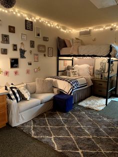 a dorm room with bunk beds, couches and lights on the wall above it