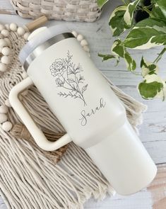 the personalized travel mug is next to a potted plant