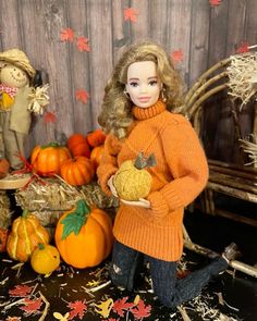 a doll is standing next to pumpkins and hay