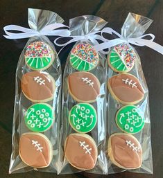 decorated cookies in the shape of footballs are packaged in cellophane and tied with a white ribbon