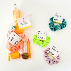 three packaged hair ties, one with an ear tag and the other with a rubber band