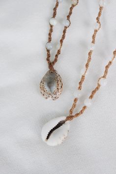 two necklaces with shells and pearls on them