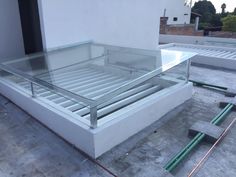 a glass table sitting on top of a roof next to a building with no windows