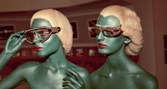 two mannequins dressed in green make up and sunglasses