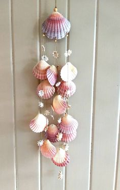 a wind chime with seashells hanging from it's sides on a wall