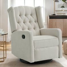 a white recliner chair in a living room next to a table with a vase on it