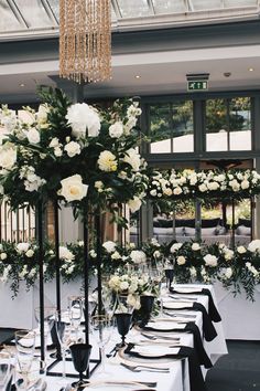 a long table with white flowers and black place settings