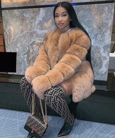 a woman is sitting on the floor with her legs crossed and wearing high heeled boots