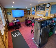 a room with several tables, chairs and a television on the wall in front of it