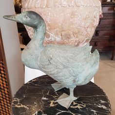 a statue of a goose sitting on top of a table