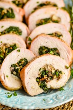 several slices of stuffed turkey on a blue plate with green garnish and nuts