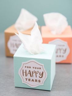 two tissue boxes with tissues in them on a table